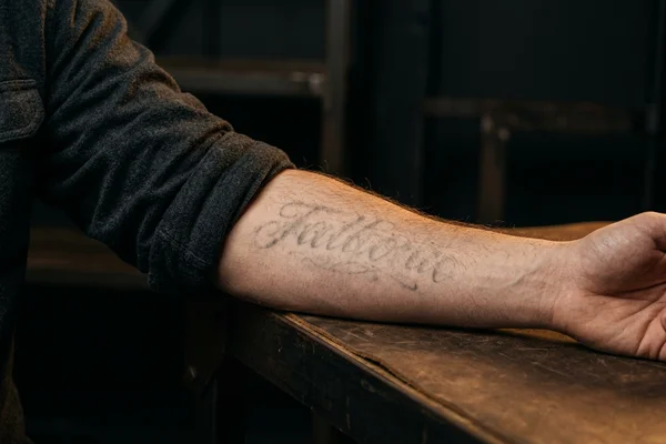 The same forearm lettering substantially lightened after a six-session fading bundle