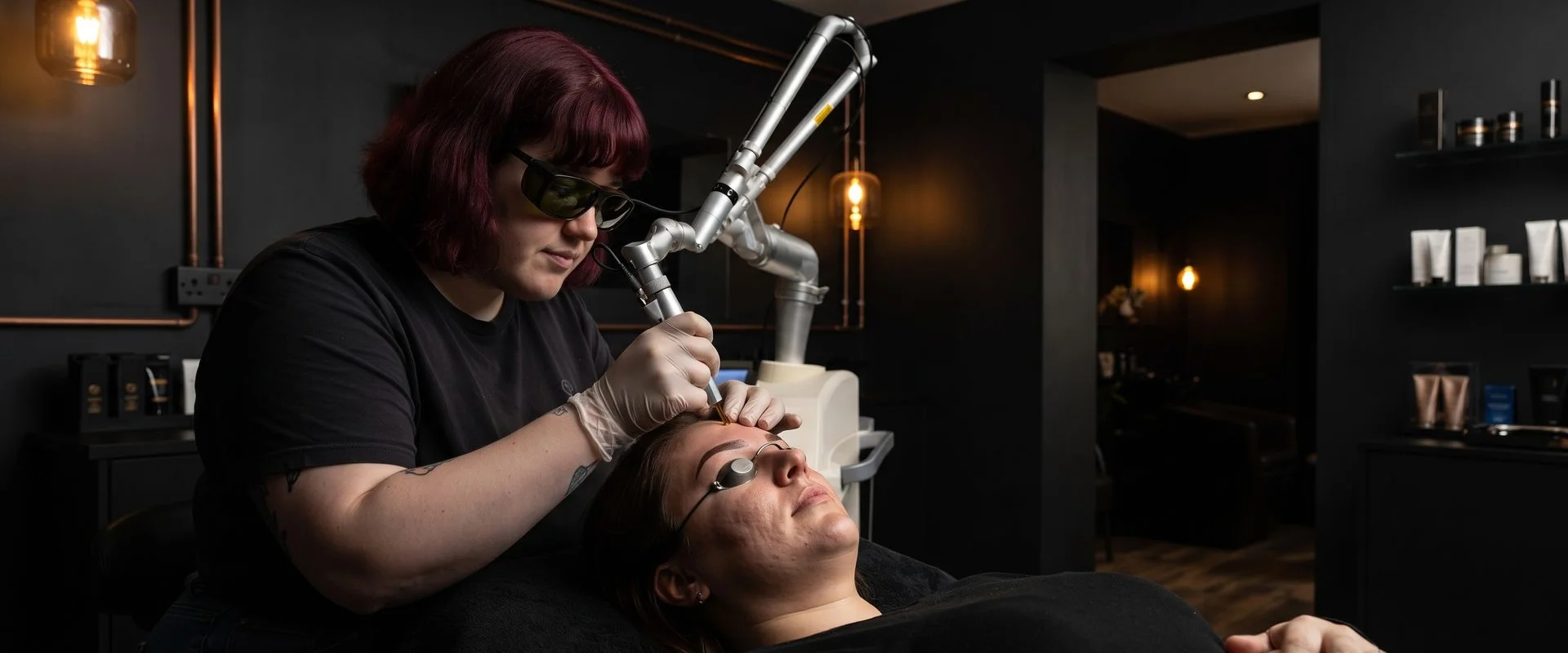 Technician performing precision laser brow pigment removal with protective eye shields in place