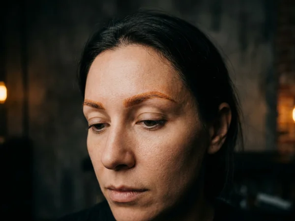 Microbladed brows that have oxidised to a warm orange tone before treatment